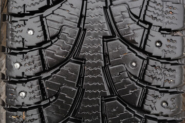 Broken studs on the surface of a car tire.
