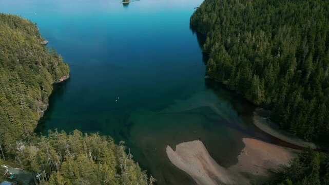 aerial view revealing Johnstone Strait near Telegraph Cover with Bauza Islet and Hanson Island in the backgrround on an overcast day, vancouver island, british columbia, canada