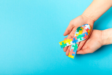Autism ribbon. Autism awareness day. World autism awareness day with puzzle pattern ribbon on textured background. Colorful puzzle ribbon. Medicine concept. Space for text. Copy space
