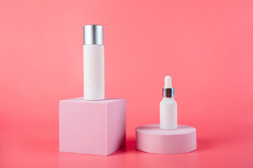 Plastic white tube for cream or lotion. Skin care or sunscreen cosmetic with stylish props on pink background.