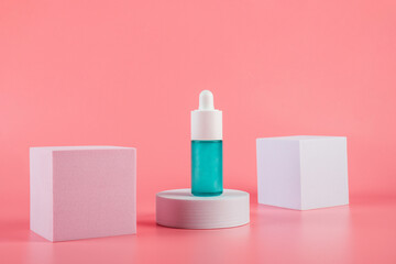 Blue glass cosmetic bottle, Skin care or sunscreen cosmetic on pink background.