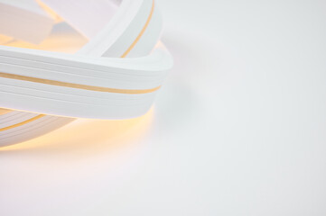 Flexible warm white led tape glowing on white background.
