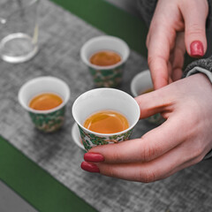 Savoring the delightful experience of sipping herbal tea from beautifully elegant cups