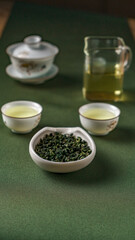 An Elegant Green Tea Setup Featuring Freshly Gathered Tea Leaves Alongside Brewed Cups