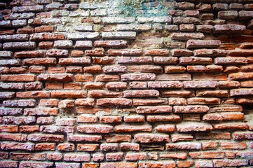 Old rustic brick wall with weathered red bricks and mortar, showcasing a vintage, textured, and historical look