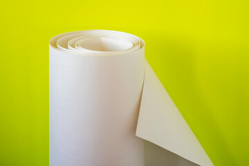 Large rolled sheet of paper on a yellow background.