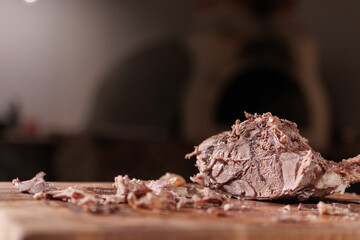 Male hands cutting cooked meat beef on a wooden board