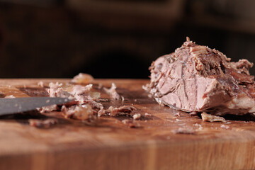 Male hands cutting cooked meat beef on a wooden board