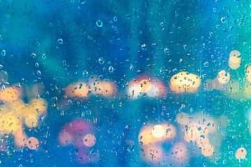 Evening rain creates a vibrant backdrop of blurred city lights and colorful umbrellas