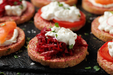 Lentil and pea protein veggie crispy cakes with cottage cheese, beetroot, tomatoes, radishes, cucumber and salmon