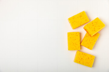 Colorful dish sponges on textured background. Kitchen sponge. Cleaning concept, cleaning service. Dishwashing liquid with clean and dirty dishes plate. Place for text, copy space. Wash the dishes.