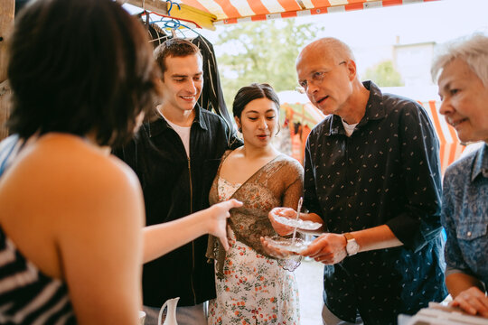Small group of people shopping at a flea market outdoors.