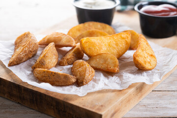 Fried potato wedges with sauces isolated on white background