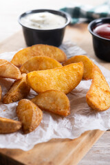 Fried potato wedges with sauces isolated on white background