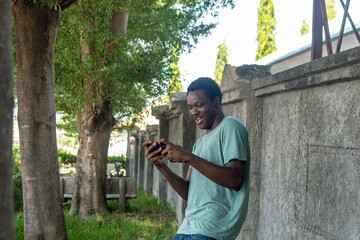 African man standing using phone.