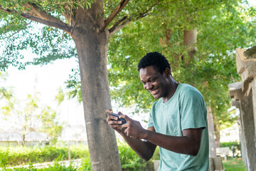 African man standing using phone.