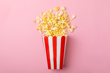 Popcorn box. Red and white striped buckets of salted popcorn on a colored background. Cinema and entertainment concept. Movie night with popcorn. Delicious appetizer, snack. Place for text.