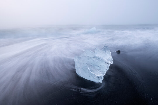 Pieces of ice on black sand at Diamond Beach near J�kuls�rl�n glacier lagoon in Iceland.