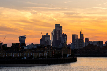 The city skyline dramatically silhouetted against a vibrant sunset, showcasing a blend of urban architecture and nature's beauty in a harmonious balance in London UK