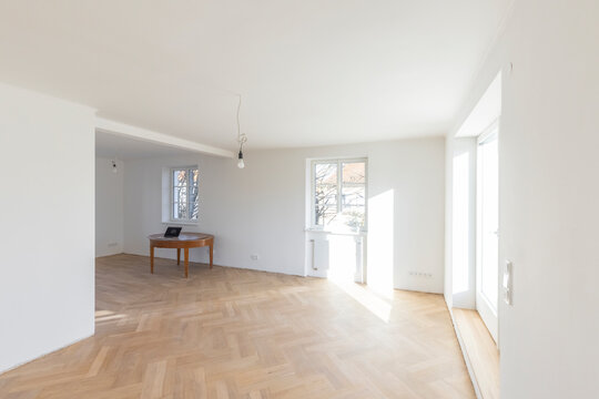 Nearly empty room with wooden floor and natural light in a home under construction