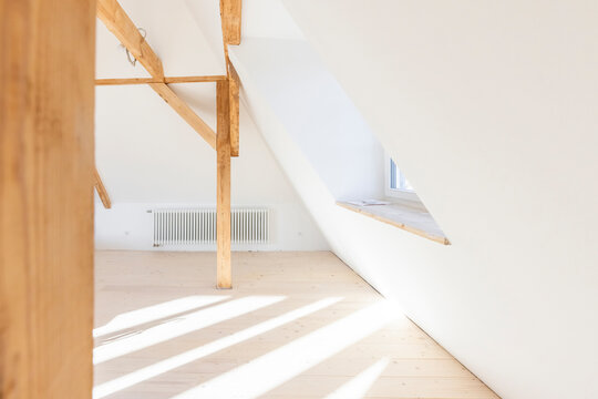 Bright attic space under construction with wooden beams and natural light