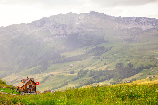Scenic view of a house with a Swiss flag in Arvenb�hl, Amden with the Mattstock summit in Eastern Switzerland
