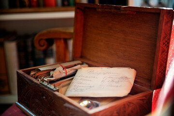 A handwritten old letter in an opened wooden box, representing memories, family history, and inheritance.