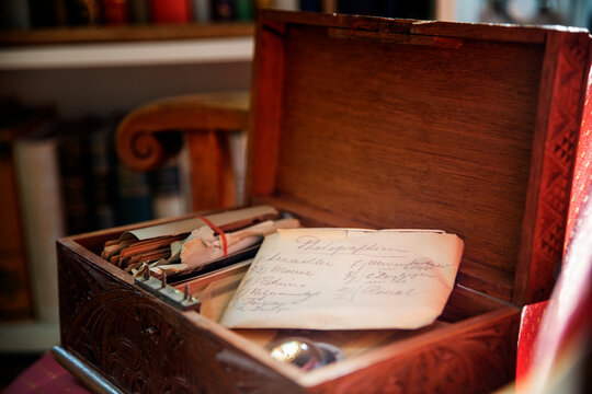 A handwritten old letter in an opened wooden box, representing memories, family history, and inheritance.