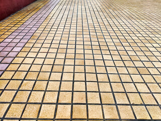 Tiled floor with a grid pattern in warm tones at an indoor location