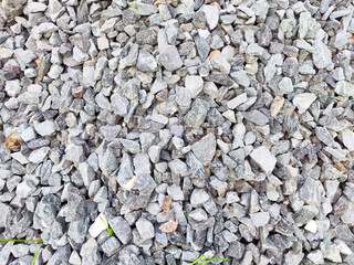 A collection of varying sizes of gravel stones scattered in a natural environment, providing ample...