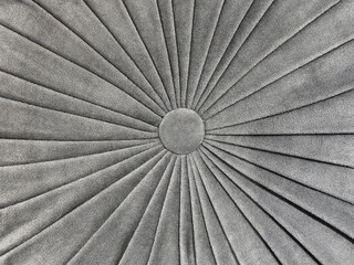 Close up of bead fabric puff seating with sunburst pattern in grey color. Suede sunburst pattern monochrome grey fabric seamless background texture.