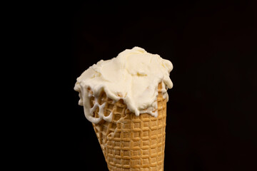 creamy ice cream in a waffle cone on a black background