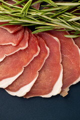 sliced ham with bacon on a board