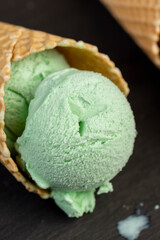 green ice cream with mint flavor on a black slate surface
