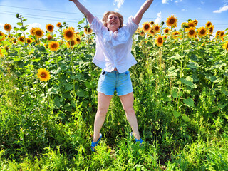 Joyful woman enjoying a sunny day in a sunflower field during her travel adventure