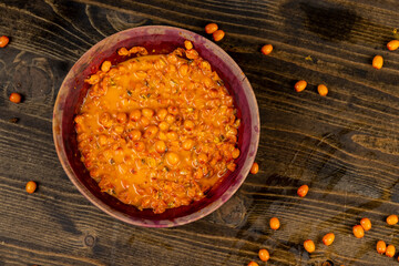 crushed sea buckthorn berries in a wooden bowl
