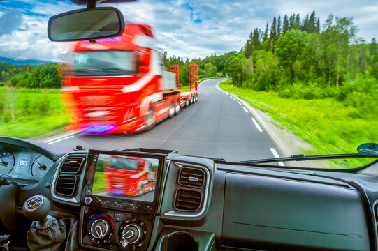 Oncoming red truck on European road E6 in Norway from vehicle interior