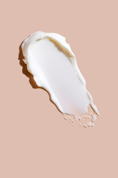 White cream texture on a beige background illustrating skincare product