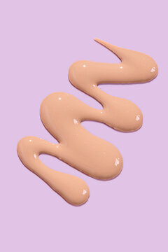 Liquid foundation texture on a pastel background