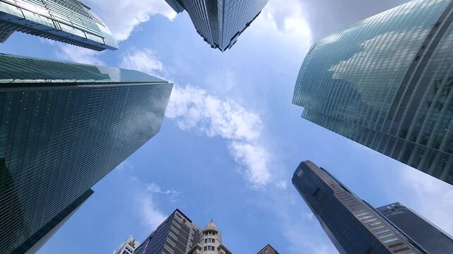 Singapore's modern skyscrapers on a sunny day. Time-lapse 4K low-angle video shot at Raffles Place.