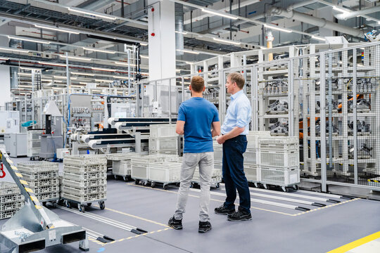 Businessman and employee talking in a factory