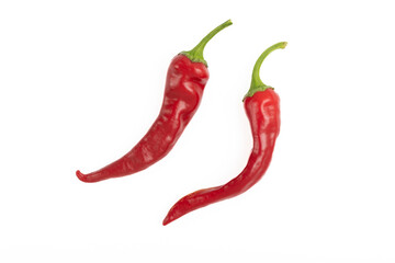 Two red hot chili peppers on a white background