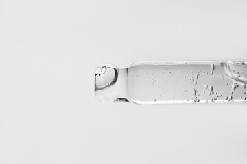 A drop of cosmetic aromatic oil drips from the pipette. Front view.