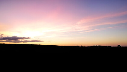 Obraz premium Silhouetted landscape with a colorful sunset sky
