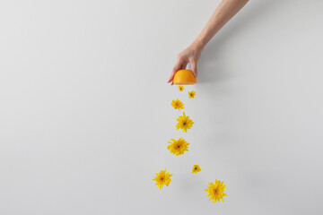 Conceptual close-up of a hand squeezing an orange to make orange juice