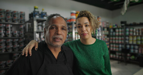 Father and daughter standing together in a paint store, smiling warmly, conveying family connection and support, surrounded by stocked shelves of colorful paint supplies