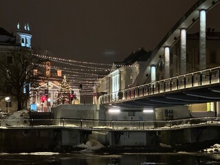 Lights on the Kaarsild or Arch Bridge over the Emajõgi river with Christmas market on background, Tartu, Tartumaa, Estonia, December 2023