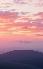 Obraz premium Serene Pink Sunset Over Distant Mountain Ranges