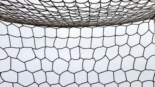 Soccer goal net close-up showing intricate design and structure at a sports field during daylight