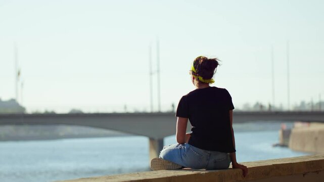 Girl watching the sunset and observing traffic on the Santa Clara Bridge, with the Mondego River in the foreground, Coimbra